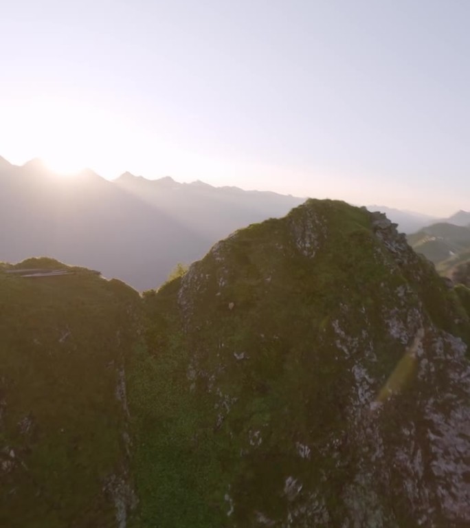垂直视频。鸟瞰阳光明媚的山脉山谷高山山羊野生动物