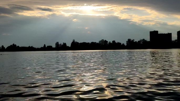 夕阳下平静的湖面丁达尔波光粼粼