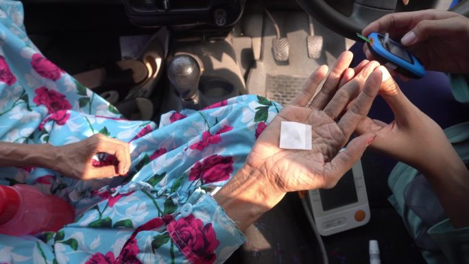 老妇人在车里做健康检查。检查血糖、血压、血压