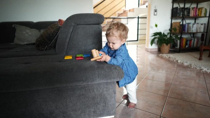 小女孩在沙发上玩木制玩具