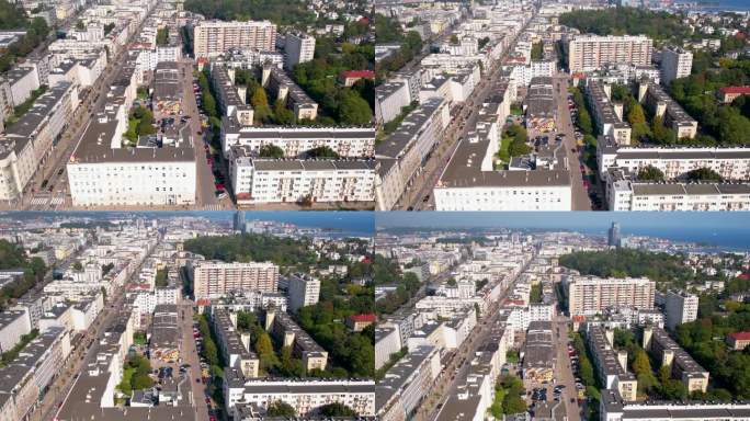 空中摄影车倾斜显示现代沿海城市格丁尼亚，白色的公寓楼排列在道路上