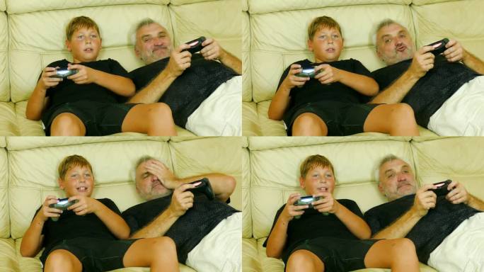 父子俩躺在沙发上玩电子游戏