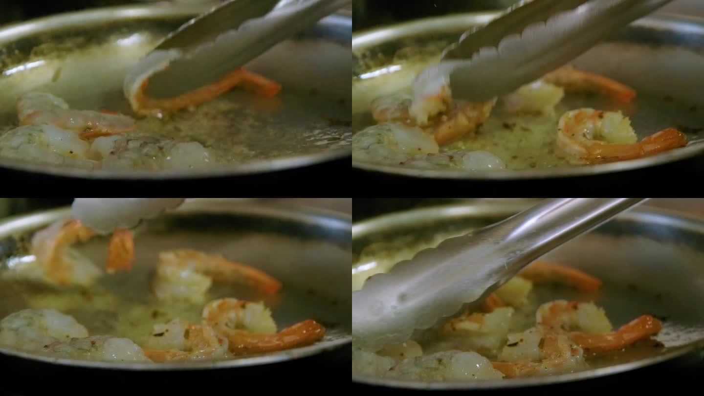 厨师用大钳在热煎锅里翻炒虾