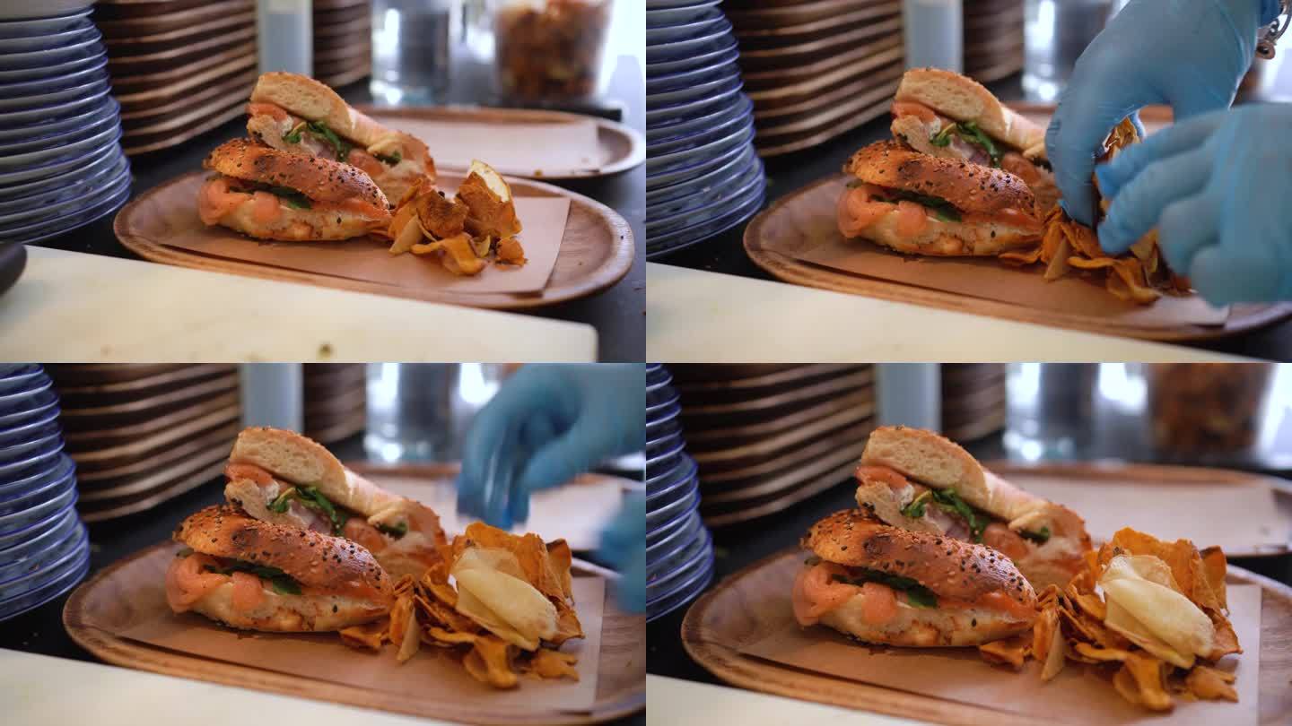 一份鲑鱼百吉饼三明治和薯片已经在厨房里准备好供顾客享用了。