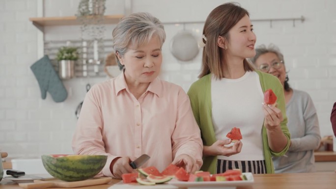 快乐的亚洲老年人在素食烹饪上的联系:厨房里的爱、笑声和团聚。