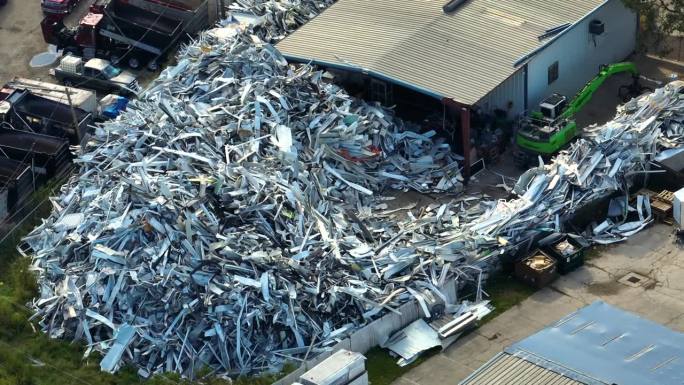 鸟瞰图:飓风伊恩横扫佛罗里达州后，从破碎的房屋中散落出一大堆废铝。循环再造流动房屋的破碎零件
