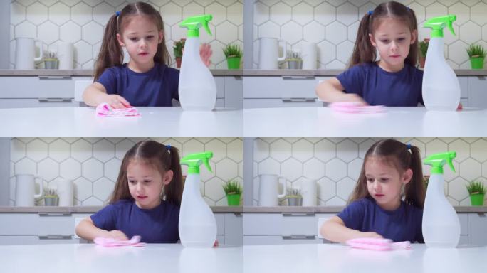 神奇的小女孩用清洁剂喷在桌子上，用抹布在厨房里清洗。做家务。