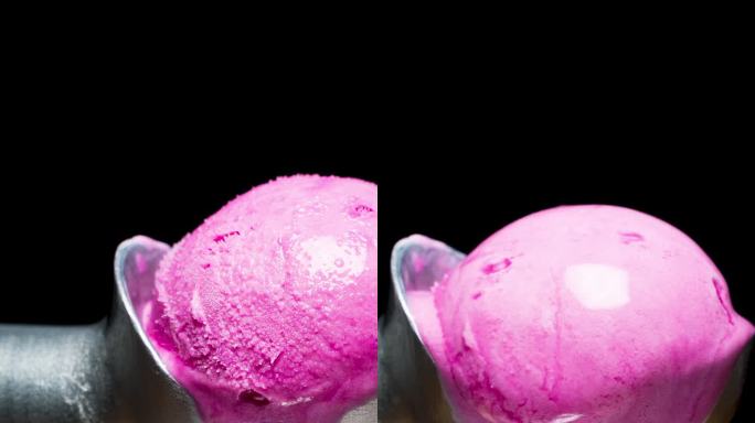 垂直视频。覆盖着冰的冰淇淋勺和粉红色的冰淇淋球融化了，滴落下来，消失了。黑色背景的延时摄影。