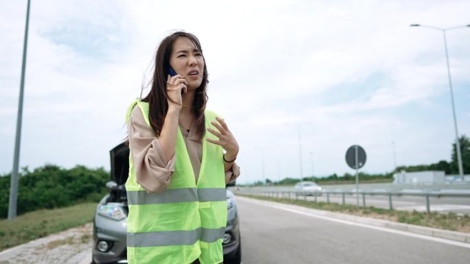 一名年轻女子在高速公路上为她坏掉的车呼救