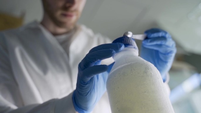 科学家或学生在实验室中清除冷冻实验室容器中的残留物