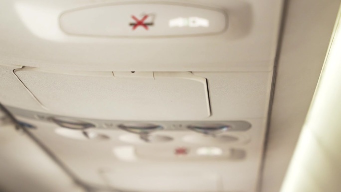 现代客机上禁止吸烟的上顶控制台近景和系好安全带标志