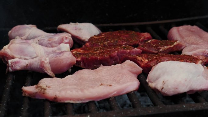 烤肉架上的生肉。鸡肉和猪肉放在烤架上烧烤