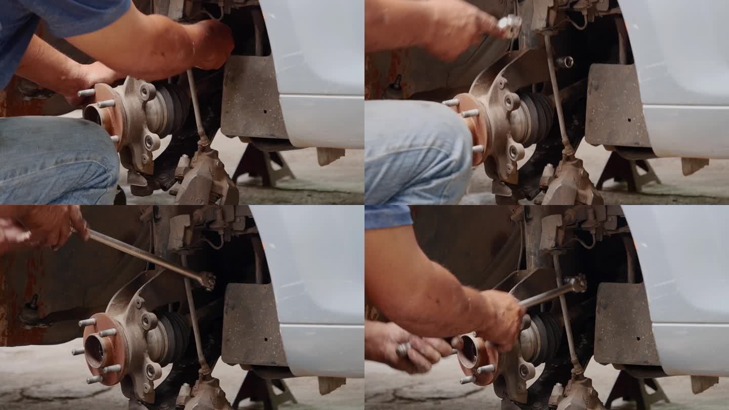 (近景)修车技工正在修车，汽车修理店用千斤顶换轮胎。手动修理减震器机械车辆机械维修。汽车大修维修工程