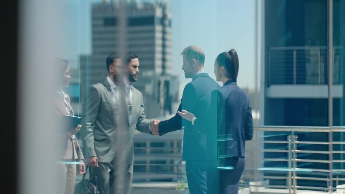 玻璃反射，会见和商务人士握手表示交易或感谢。合作伙伴、合同和公司员工握手表示欢迎、同意或合作