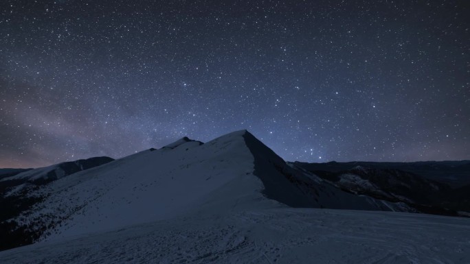 繁星满天的夜空中，银河系的星星在冬季阿尔卑斯山上快速运动，在冰冻的白雪皑皑的自然中天文延时4k uh