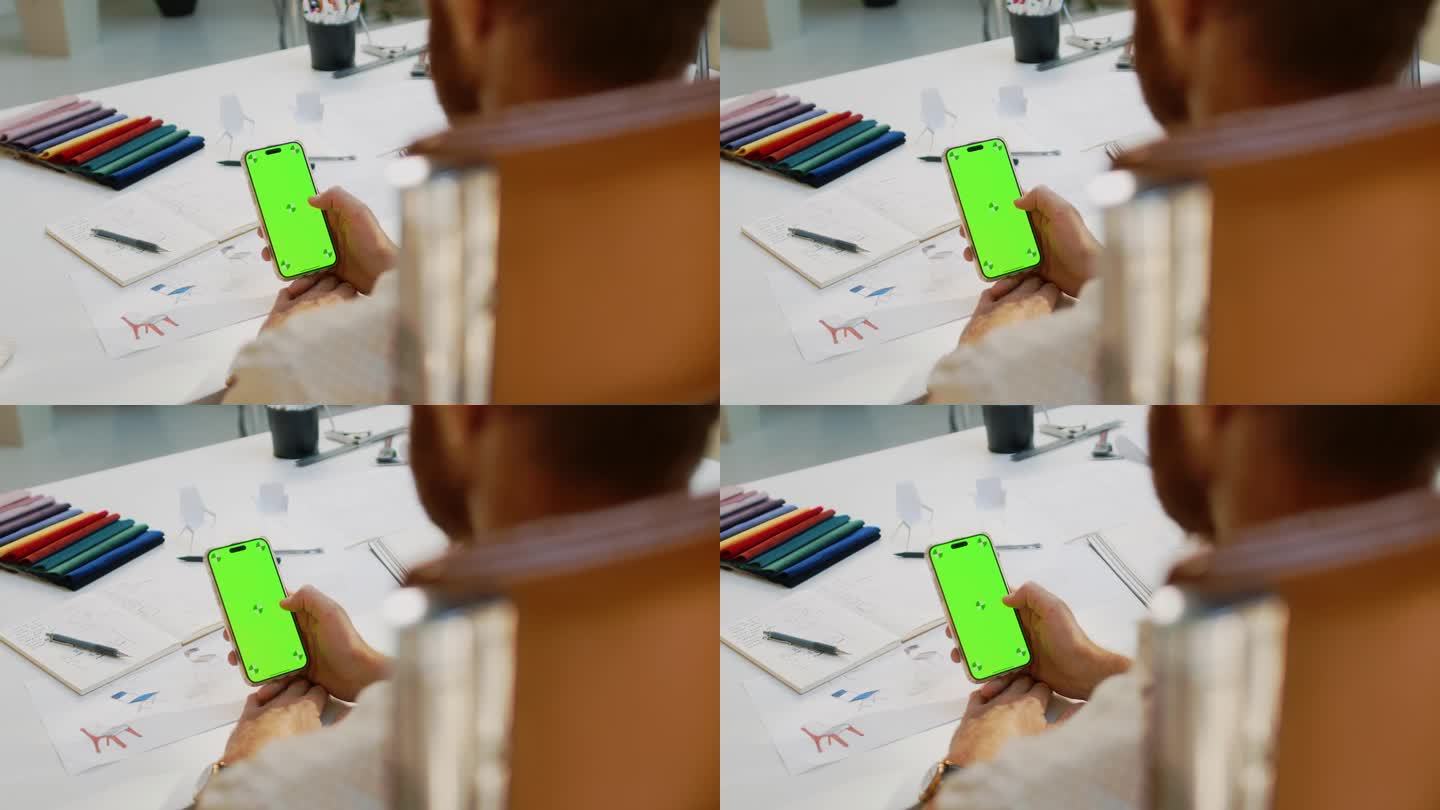 男子在工作室里拿着带有色度键屏的智能手机