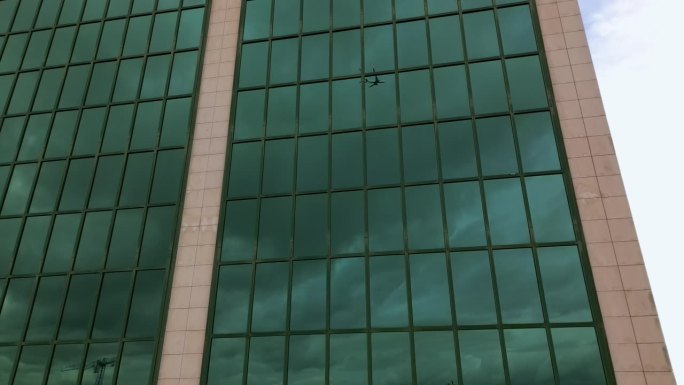 一架商用飞机映照在葡萄牙里斯本一座建筑的窗户上