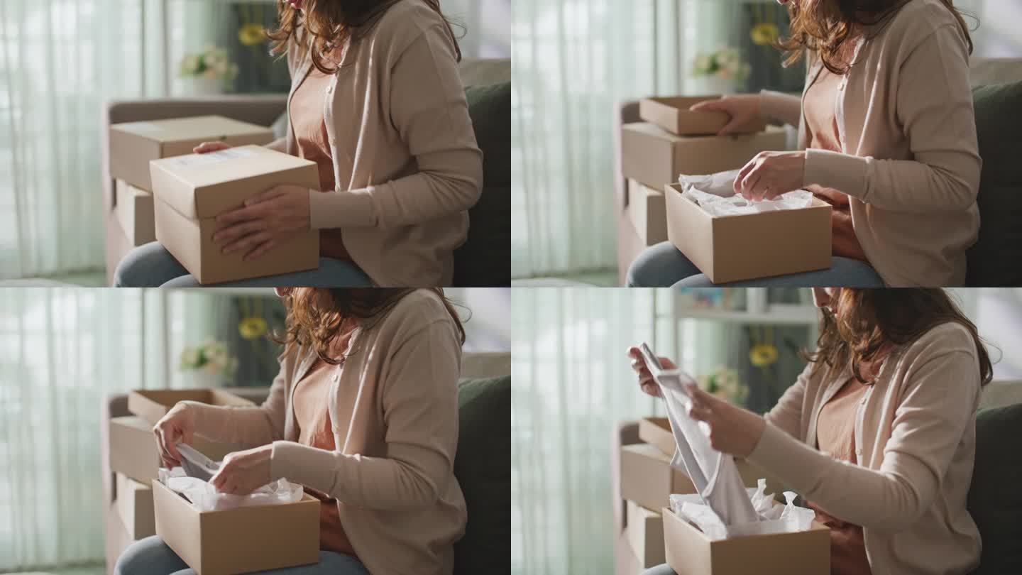 一名亚洲女子收到了一个纸板箱，用于网购和送货到家