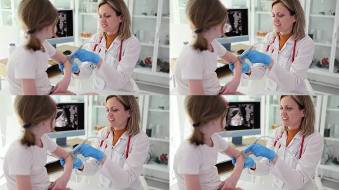 超声医生在诊所对小女孩的肘部进行超声检查