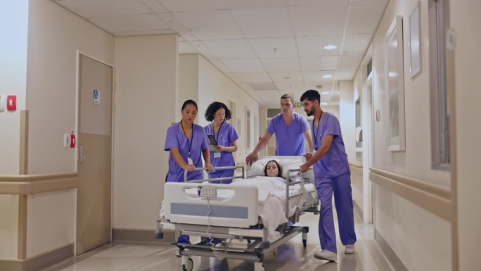 一群多种族的护士在医院走廊上推着装有昏迷病人的轮式病床