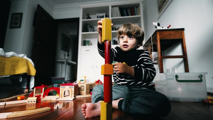 小男孩搭高楼，把古董积木叠在一起，孩子沉浸在自己的世界里，注意力集中，自己玩