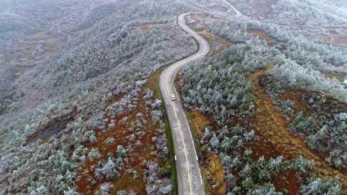 凝冻天气在高原山区盘山公路上行驶的小汽车