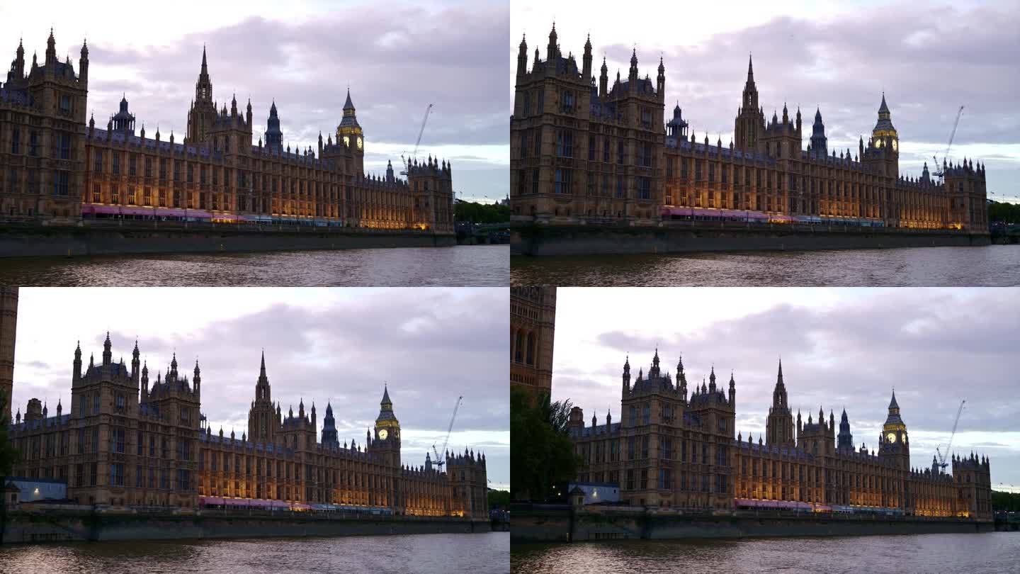 日落时分，从泰晤士河上漂浮的船上俯瞰伦敦，英国。威斯敏斯特宫和伊丽莎白塔