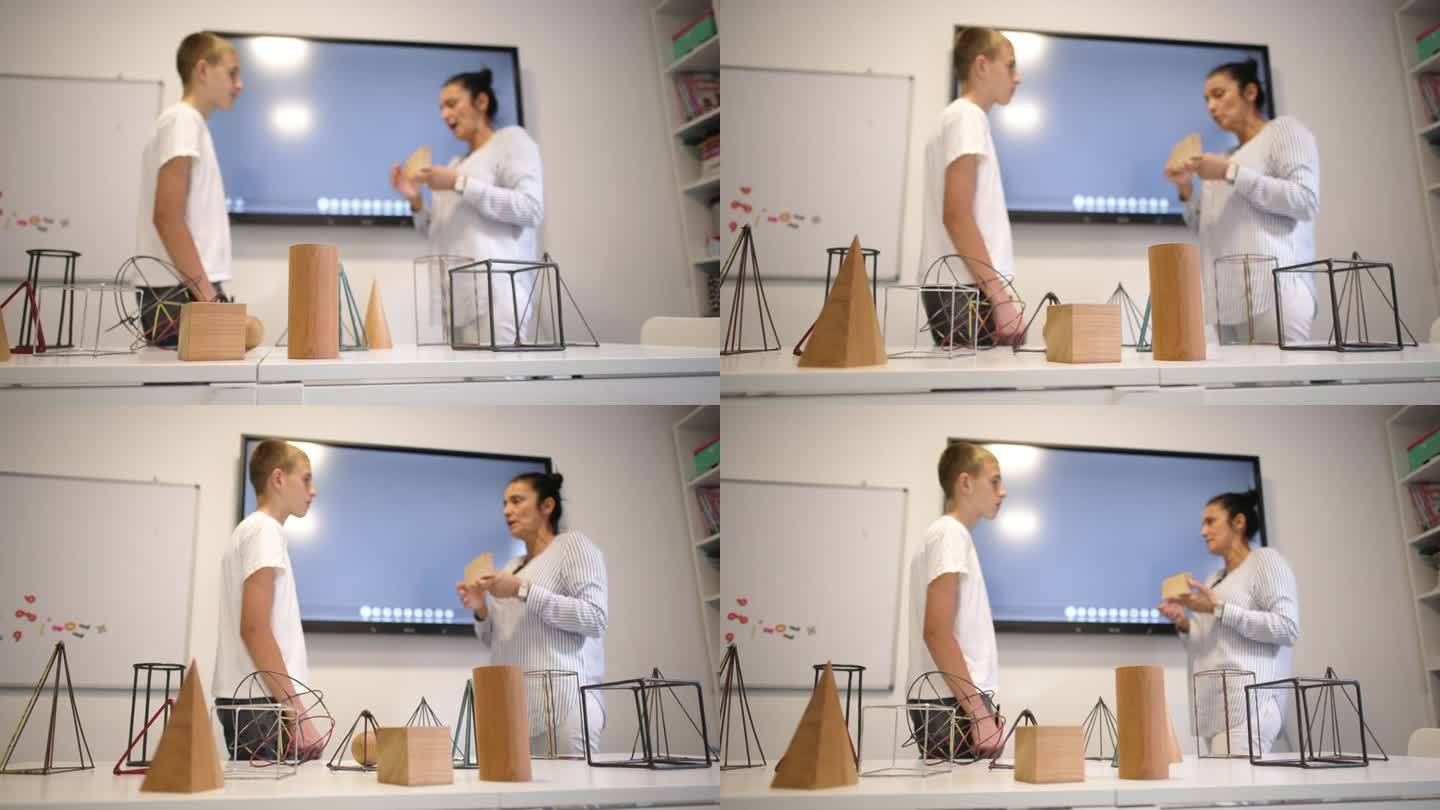 在一所私立学校的教室里，一名白人女几何老师正在和一名男小学生进行一对一的教学