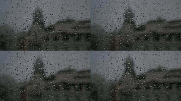 在一个黑暗、阴沉、多云的天气里，一个下雨的玻璃的特写镜头，雨滴落在窗户上。