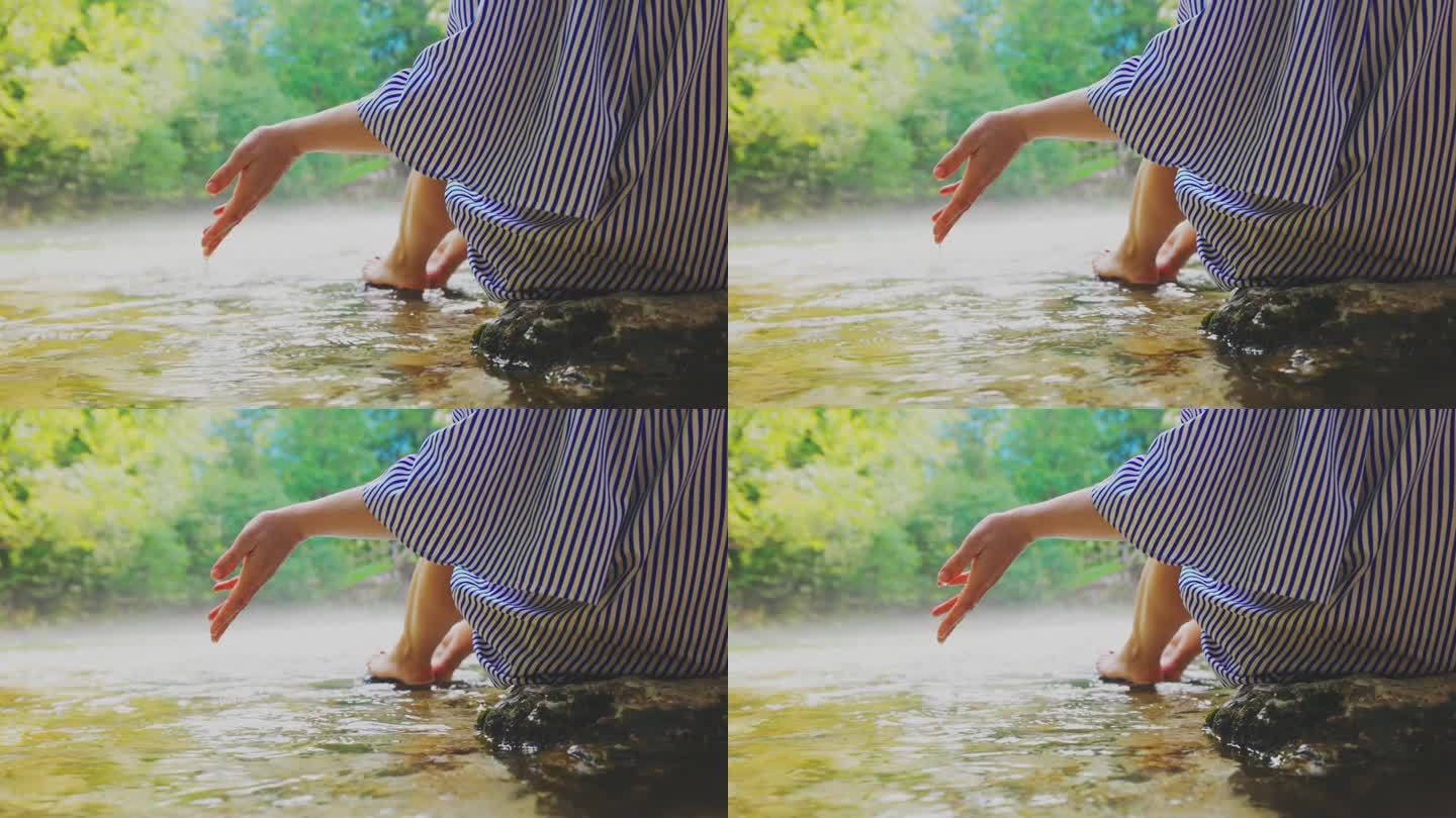 一个女人在森林里的河里玩水。手捧清泉。清水如水晶