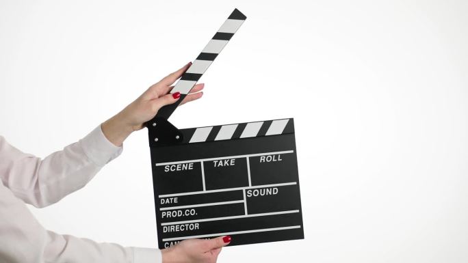 在拍摄白色背景的电影时，一名女子手持电影板