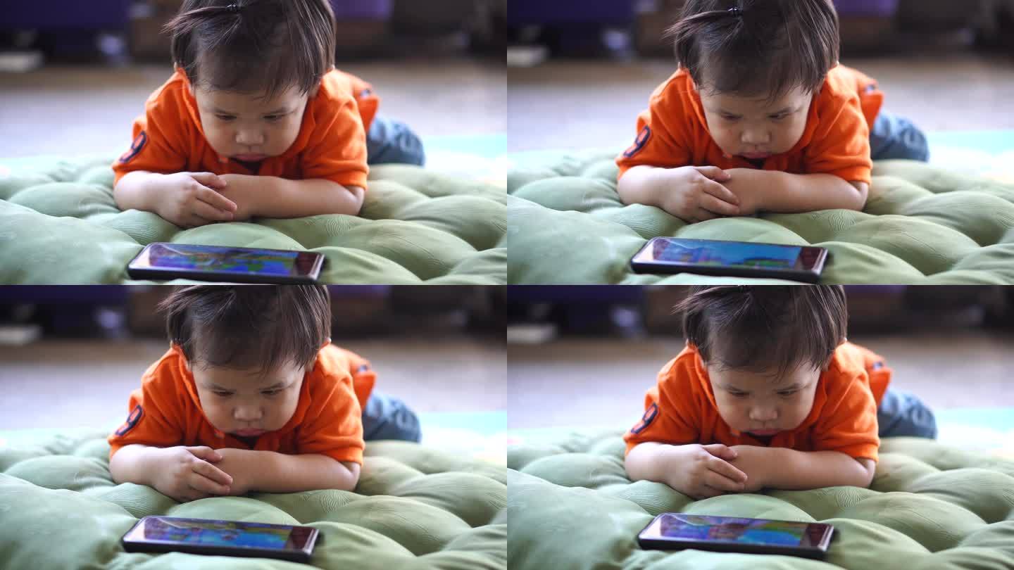 儿子躺在屋外看他的智能手机。