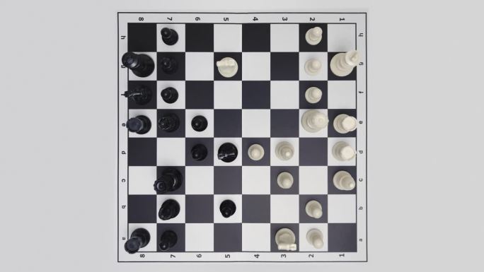 自上而下的视图停止运动延时下棋游戏在白色背景。移动的国际象棋人物