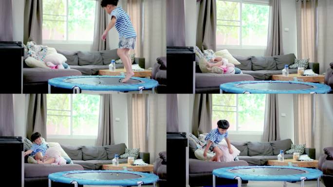 小男孩在家里客厅的蹦床上蹦蹦跳跳。