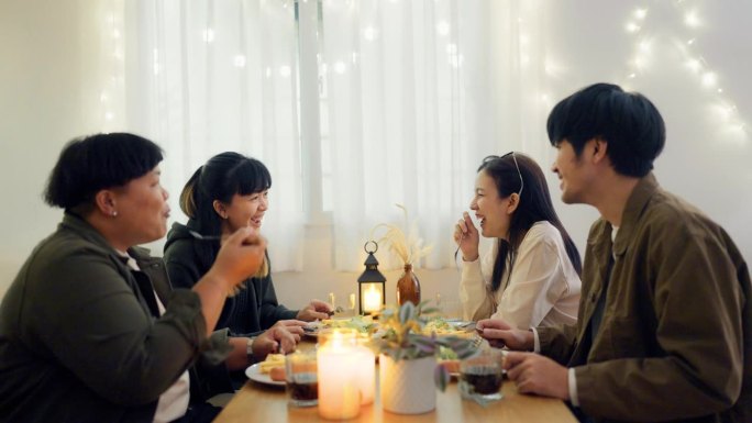 一群亚洲朋友在客厅里愉快地聊天和吃饭