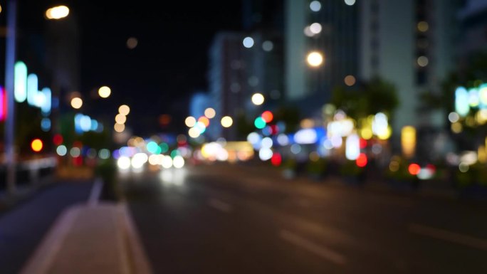 道路交通散焦，交通城市夜行。模糊的灯光散景汽车前灯行驶傍晚的城市道路。模糊的夜晚城市交通。汽车和公共