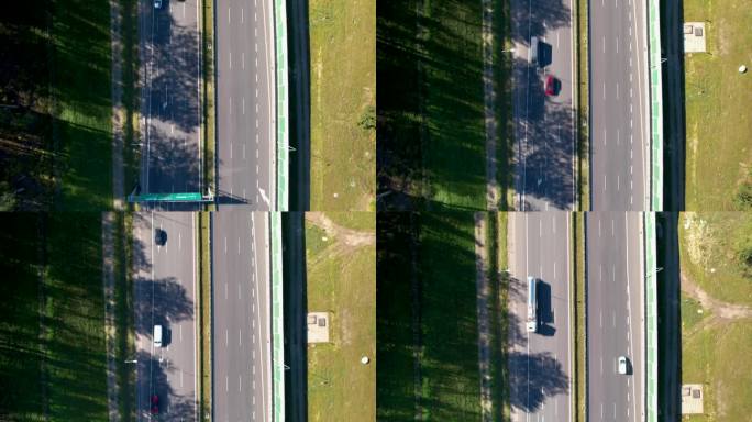 空中俯瞰——有超速汽车的快速移动的道路——指示车道尽头的箭头——街道附近的隔音屏障——车道附近的树木
