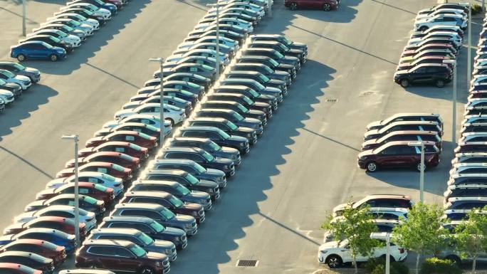 当地经销商的大型停车场，有许多全新的汽车停放出售。美国汽车工业的发展与整车概念的分布