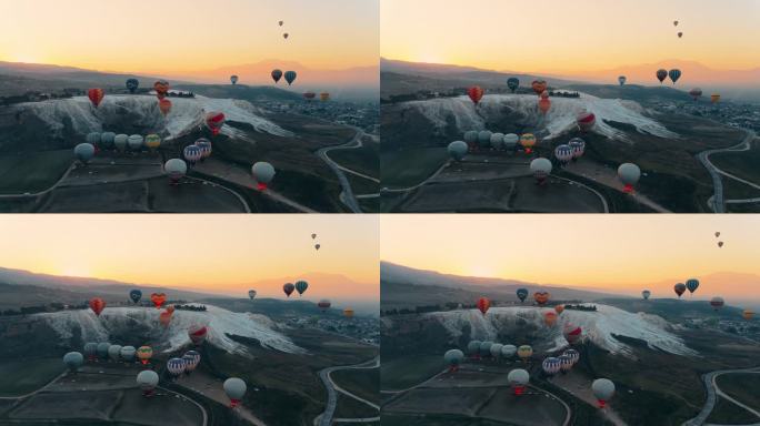 热气球在Pamukkale山谷上空升起，映衬着群山和忧郁的天空。航拍无人机视频