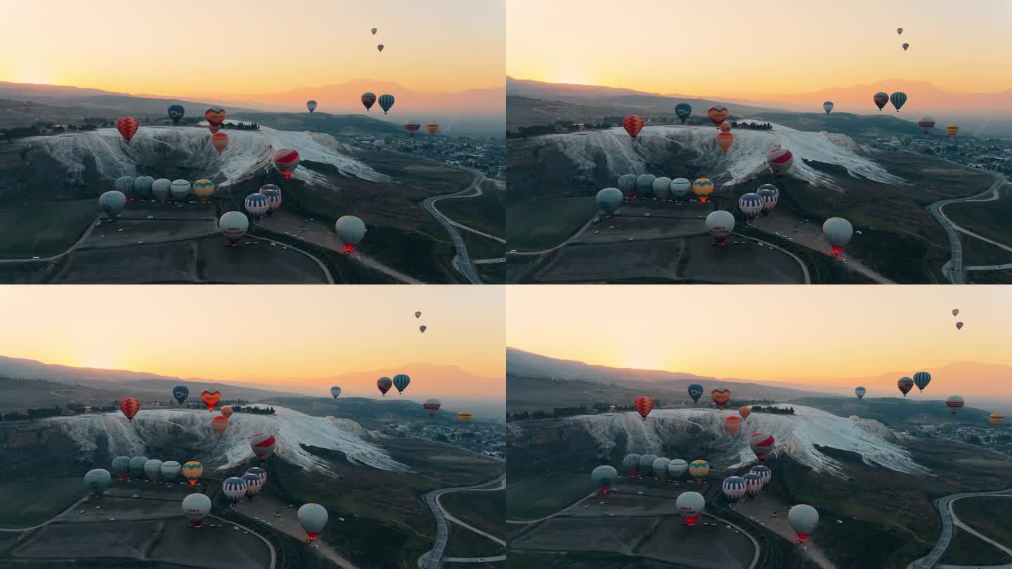 热气球在Pamukkale山谷上空升起，映衬着群山和忧郁的天空。航拍无人机视频