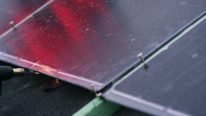 防火太阳能板在受控环境下着火的耐久性测试。发光的红色塑料表面