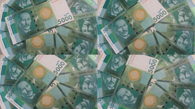 1000张吉尔吉斯钞票的特写，扇子放在桌子上旋转。一万五千美元，