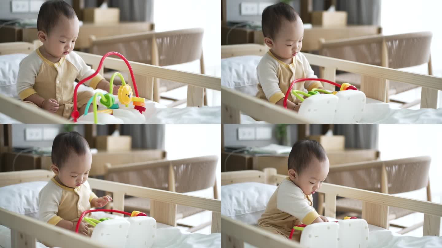小男孩在家里卧室的婴儿床上玩彩色玩具
