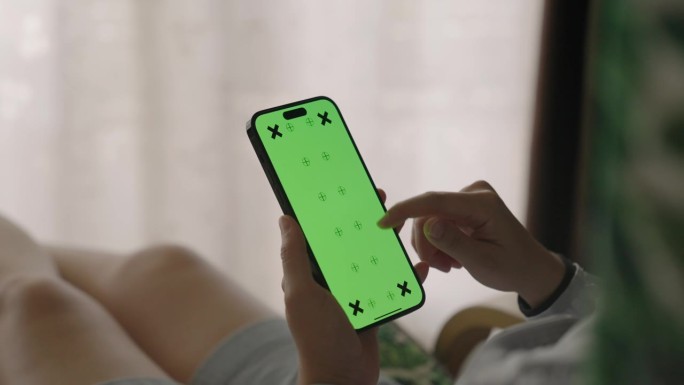 女子手持绿色屏幕的智能手机，特写