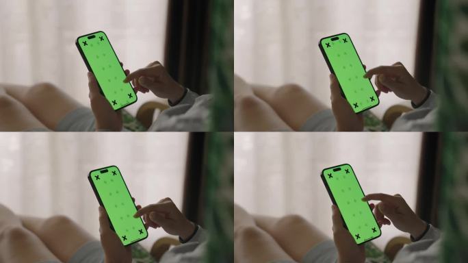 女子手持绿色屏幕的智能手机，特写