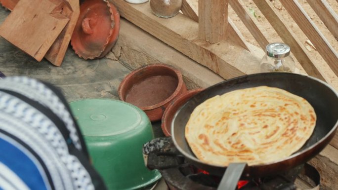 传统的非洲烹饪场景，以chapati为特色，这是一种面饼，在平底锅上明火烹饪。