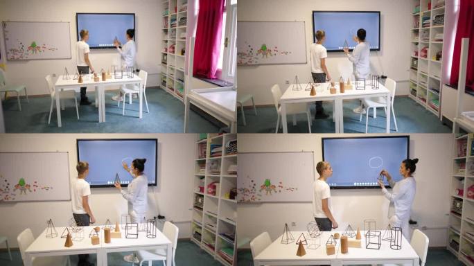 女几何老师在互动白板上画几何图形，与一名男生进行一对一的教学