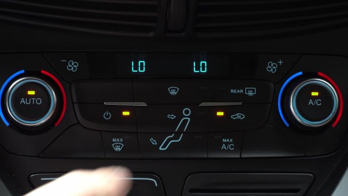 手指按下按钮，打开乘客舱空气再循环模式，车内两相气候控制