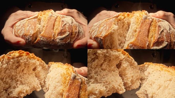 面包师正在掰新鲜的热面包。男面包师正在掰开自制的面包。