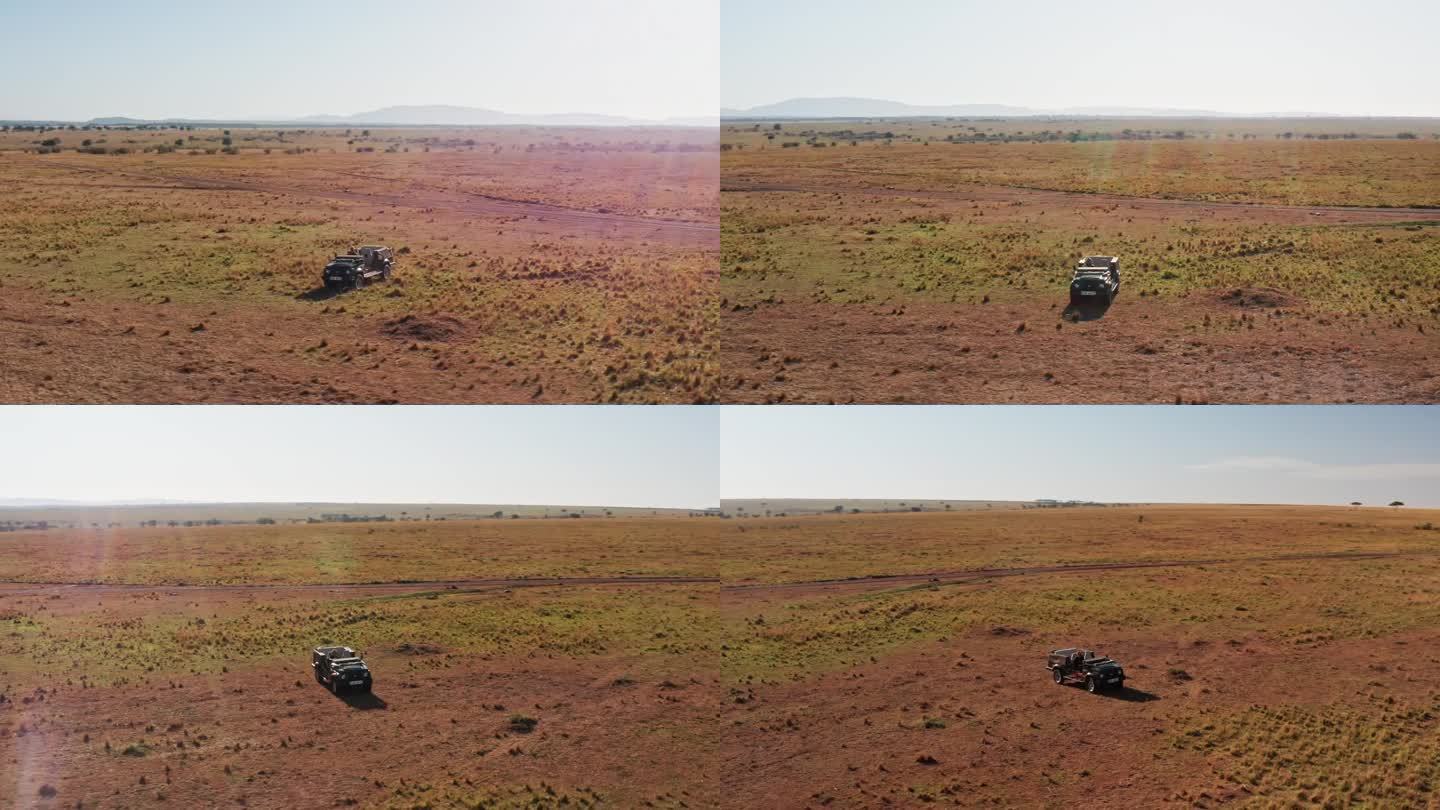 无人机拍摄的野生动物摄影师驾驶游猎车在马赛马拉国家保护区稀树草原，肯尼亚，非洲与美丽的风景，马赛马拉